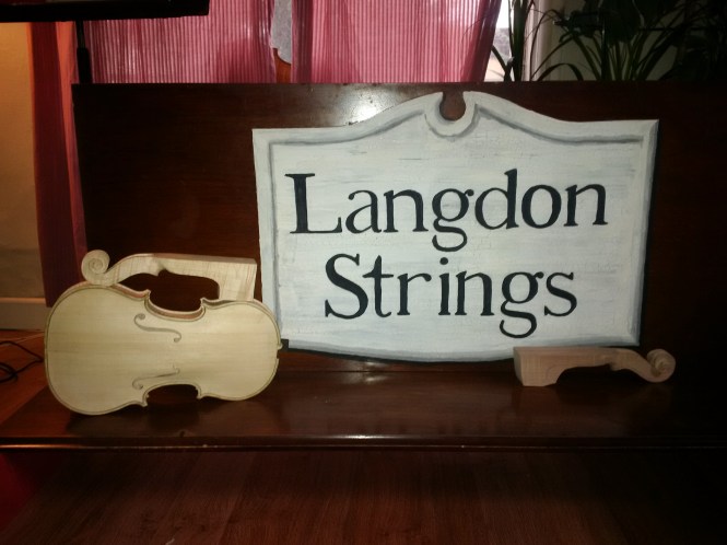 Handpainted sign done by Rose Langdon, with in progress violins. 